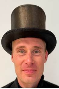 Ein Bild, das Kleidung, Kopfbedeckung, Hut, Menschliches Gesicht enthlt.

Automatisch generierte Beschreibung