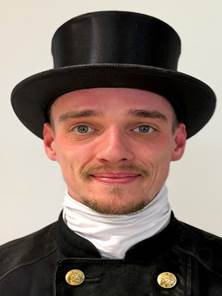 Ein Bild, das Kleidung, Hut, Menschliches Gesicht, Kopfbedeckung enthlt.

Automatisch generierte Beschreibung