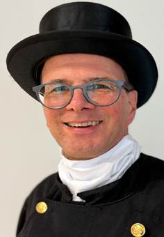 Ein Bild, das Kleidung, Menschliches Gesicht, Hut, Person enthlt.

Automatisch generierte Beschreibung